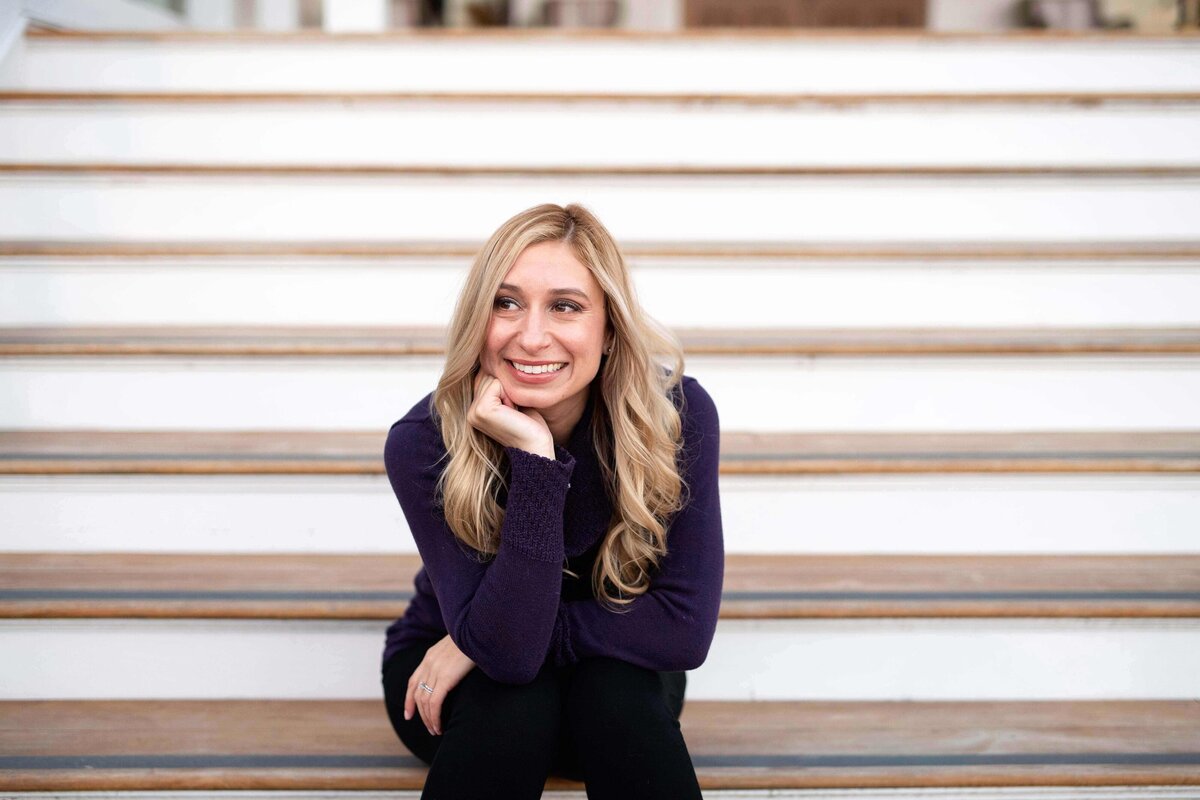 Alex Brzozowski sits on stairs at Hotel Del during lifestyle shoot for Be Organizing.