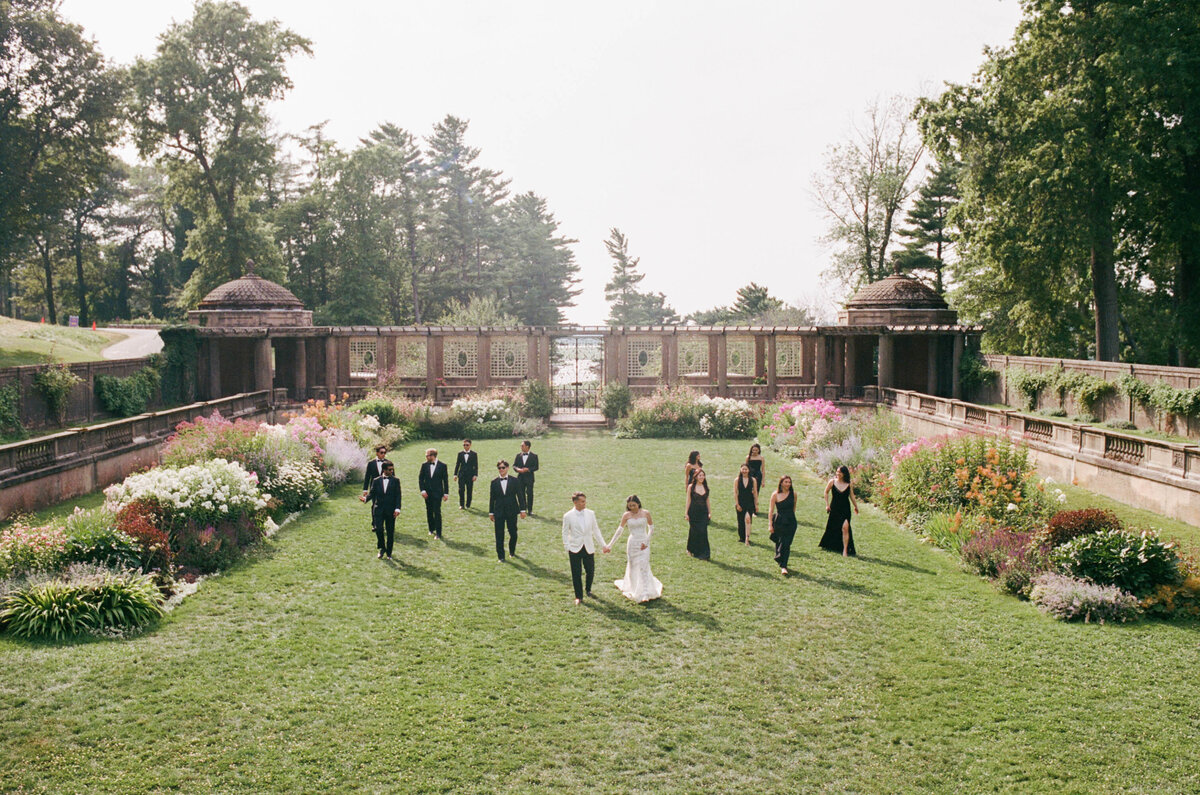 bridal party walks through gardens at crane estate in ipswich taken by boston documentary wedding photographer