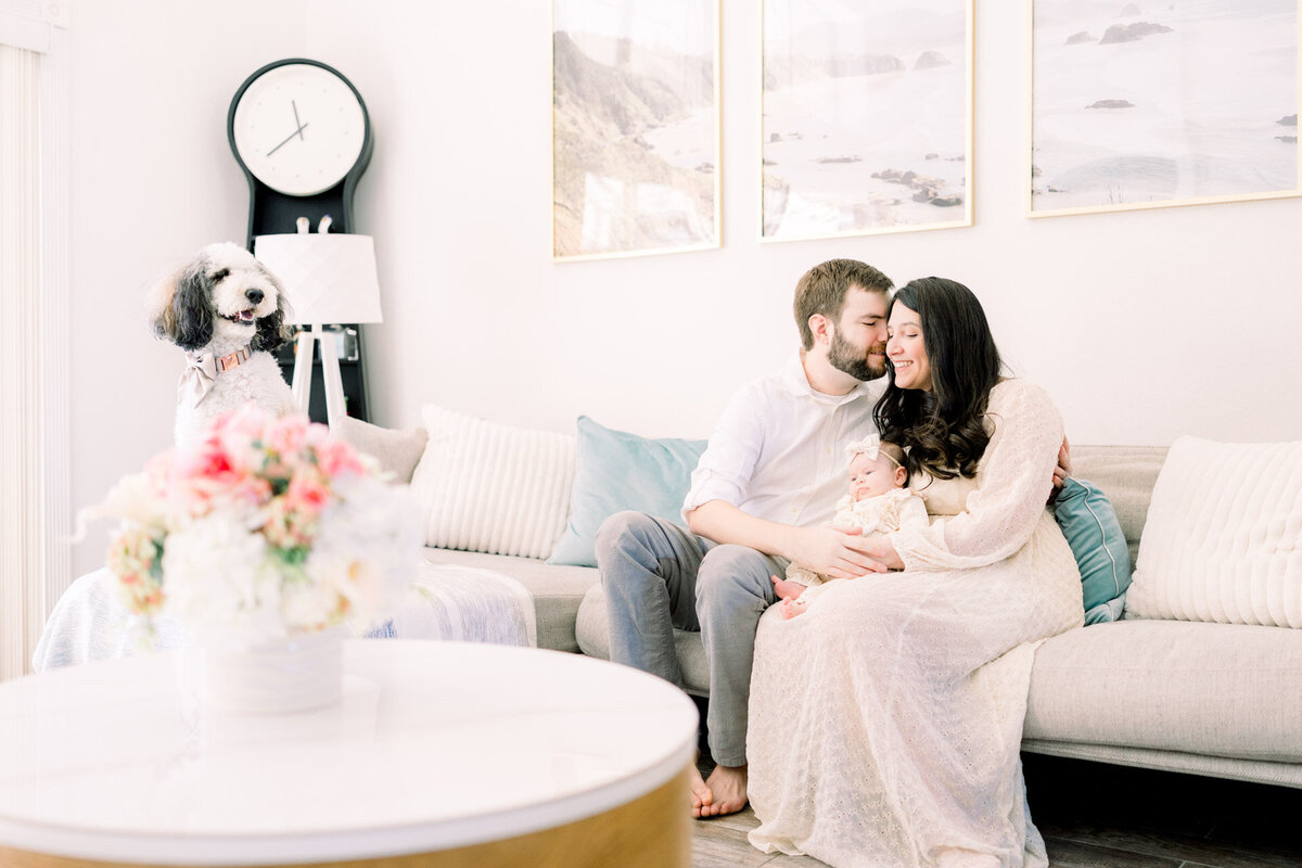 Parents holding baby on sofa for Tampa newborn photographer Tina Marie Studio.