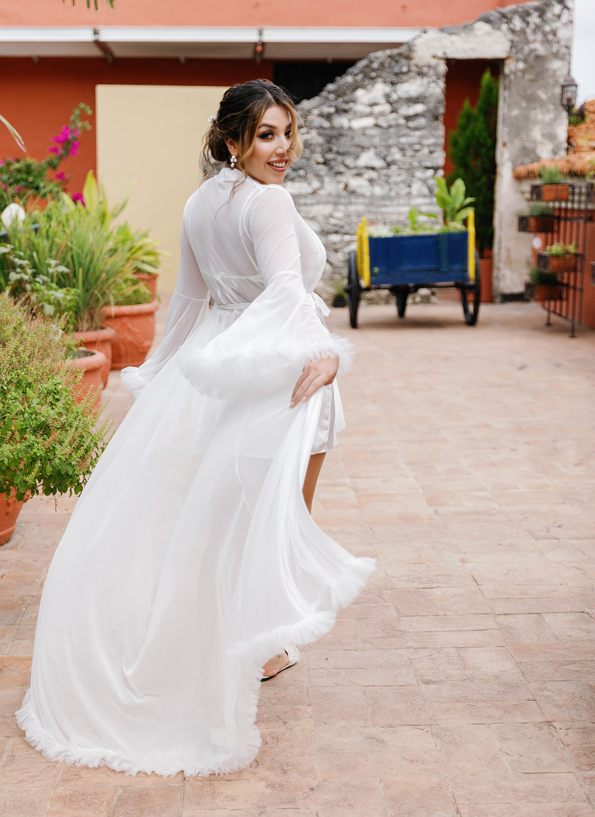 A joyful moment as Victoria twirls in her elegant bridal robe, embracing the excitement of her Cartagena wedding day.