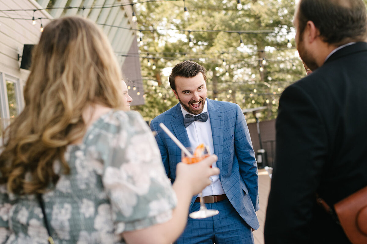 Wedding guests erupting in laughter during the reception, photographed in a natural, storytelling style.
