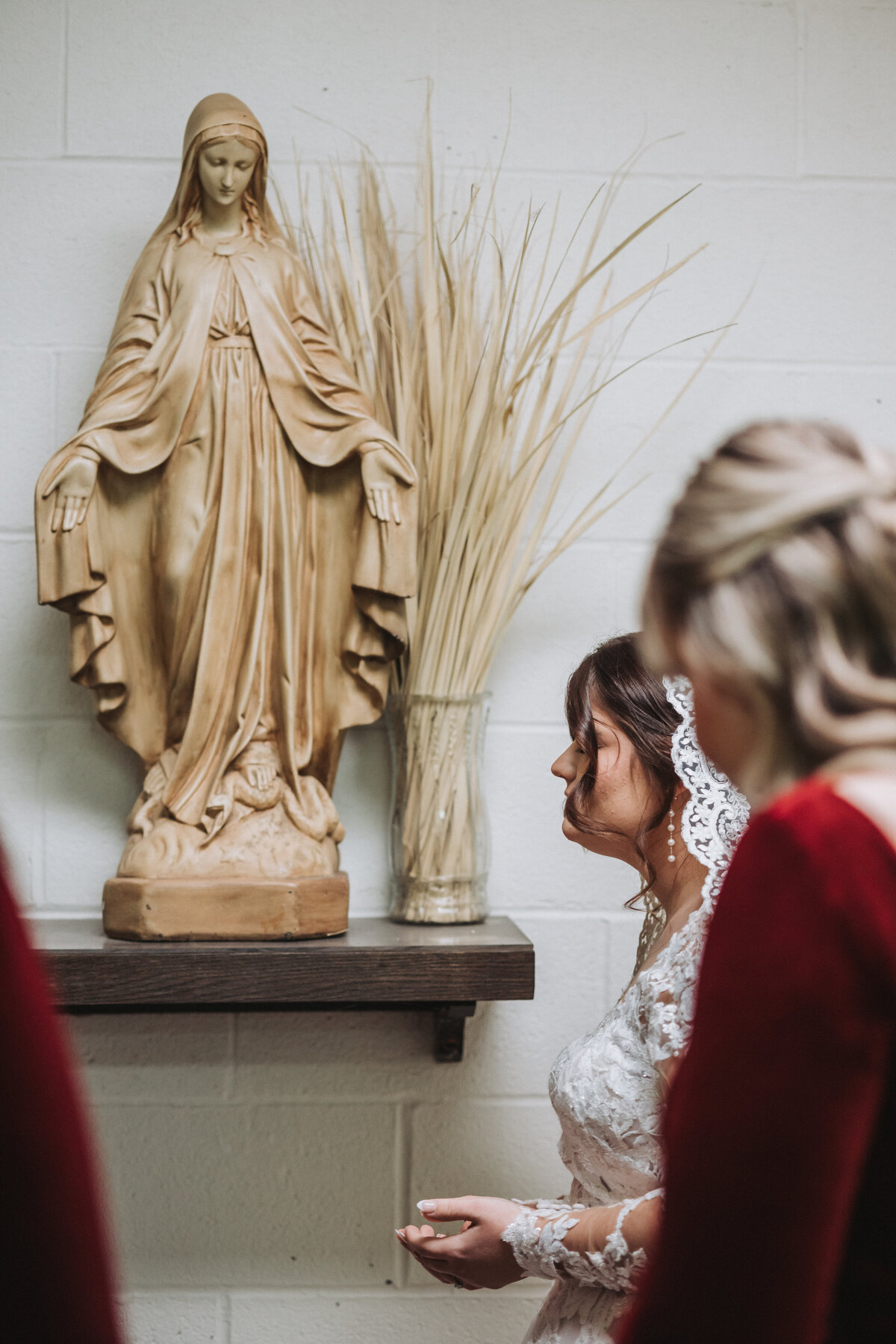 Bride-praying-with-bridesmaids-before-Mass