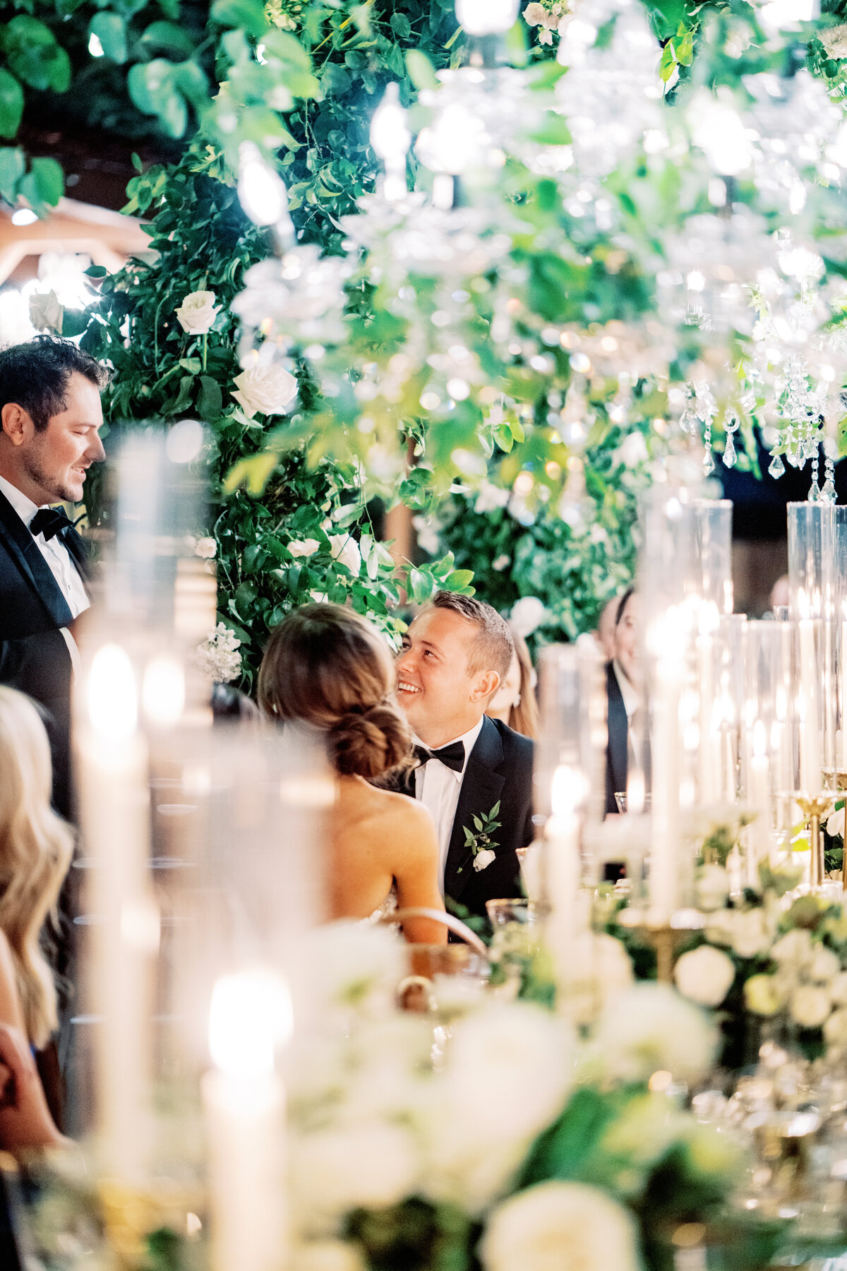 A breathtaking wedding reception with lush floral arrangements and glowing candlelight, creating a romantic and intimate ambiance for guests.