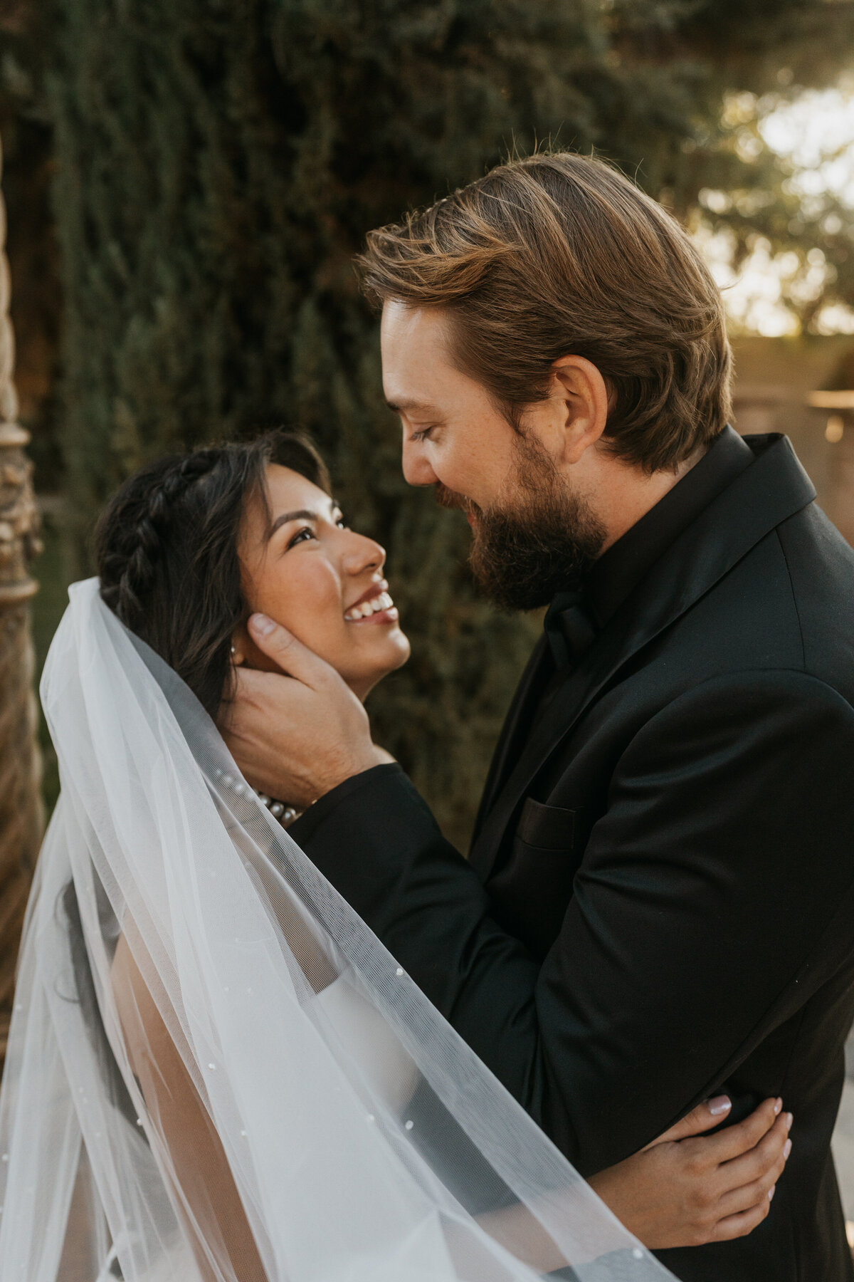 A person with their hands on their partner's face as they lean down to kiss each other 