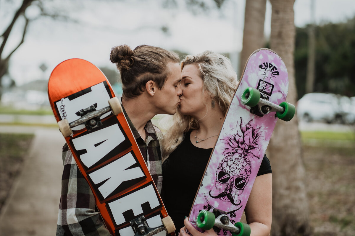 couple kissing between skate boards