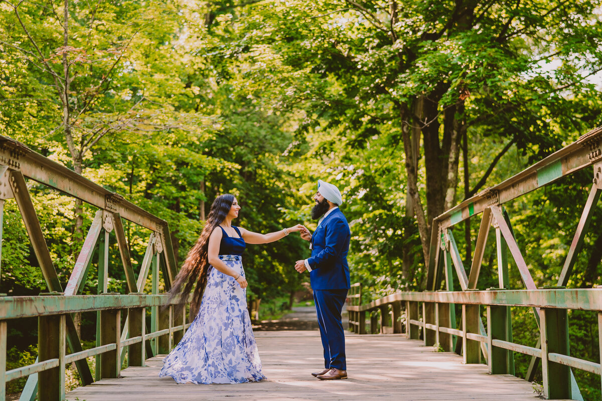 A couple twirling on a pedestrian wood bridge at ramapo valley reservation in nj