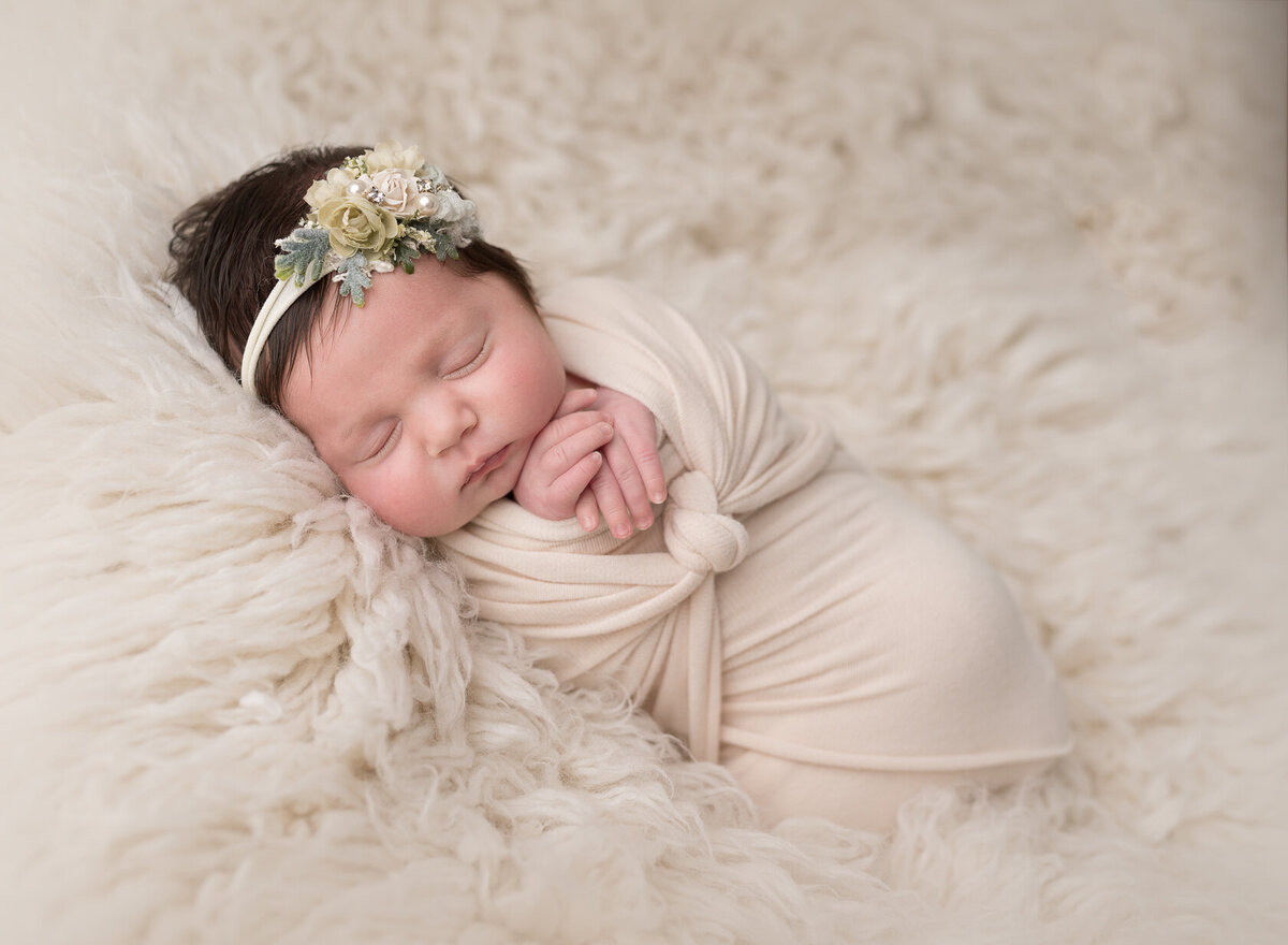 Creative newborn photoshoot in cream fur background