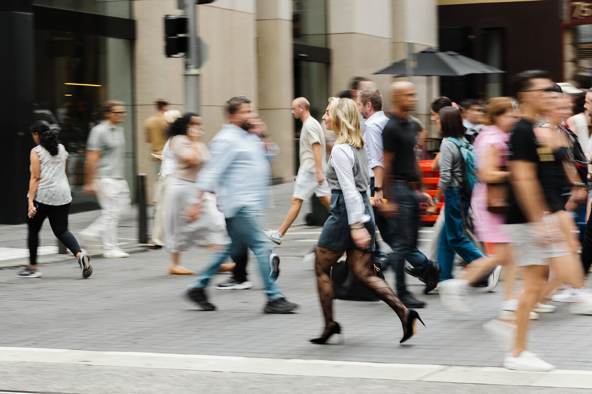 Entrepreneur confidently walking through Sydney city streets during a personal branding photoshoot, capturing a sense of movement, focus, and visibility.