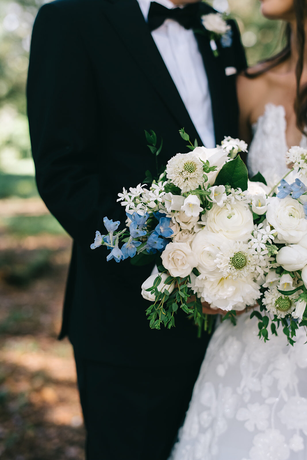 Bride and groom with white and blue bouquet designed by Abby Grace Florals at Greenville SC wedding