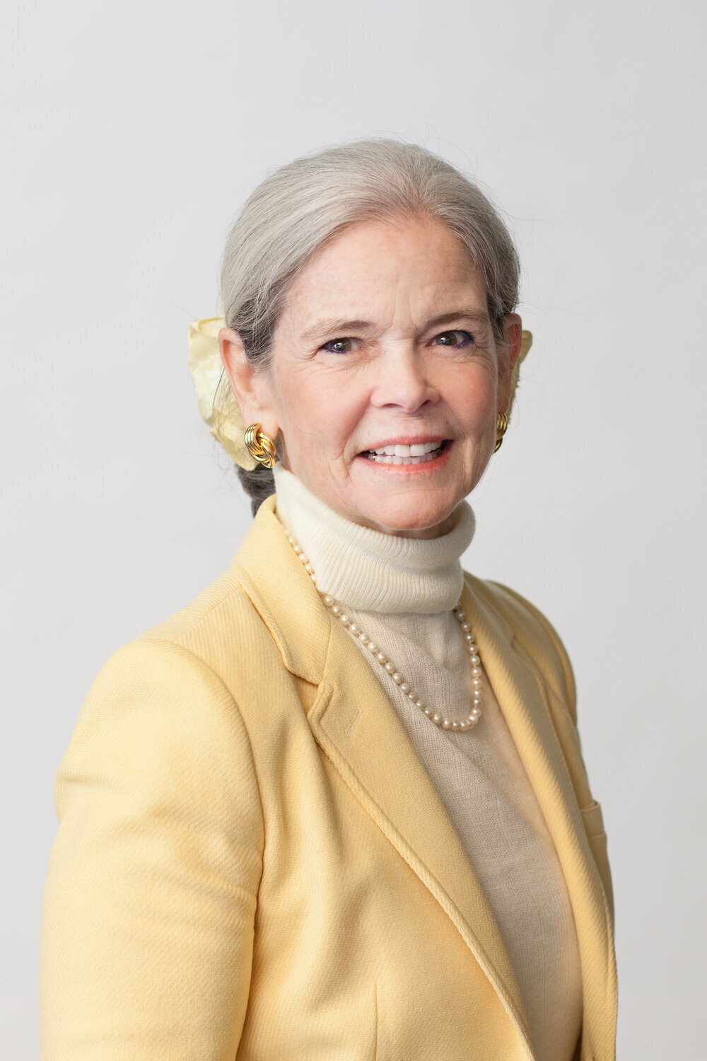 Smiling woman in soft yellow blazer