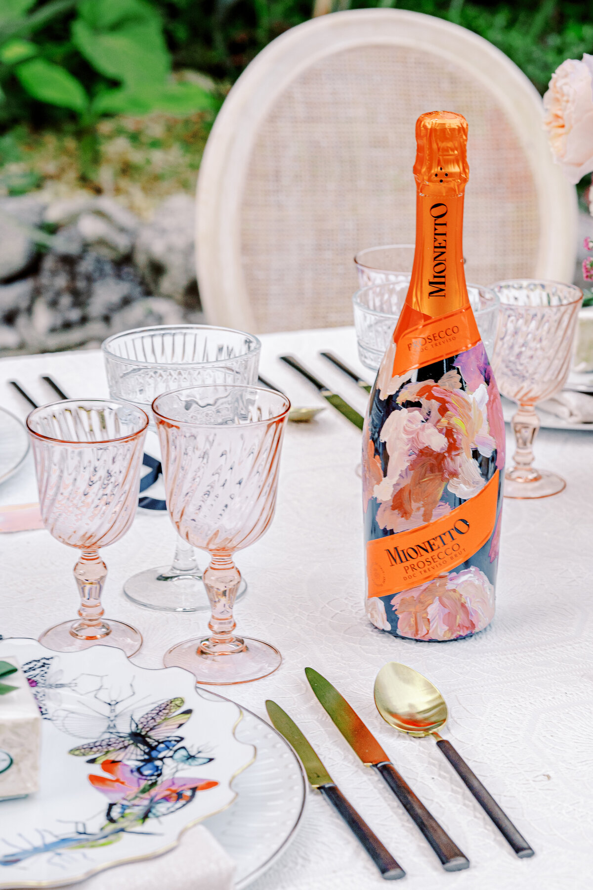Lake Como Italy wedding reception table of colorful butterfly plates and handpainted Prosecco bottles photographed by Lake Como Wedding photographer