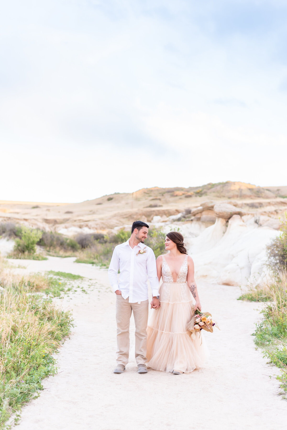 Bride and groom walking holding hands at Painted Mines Park in Colorado Springs