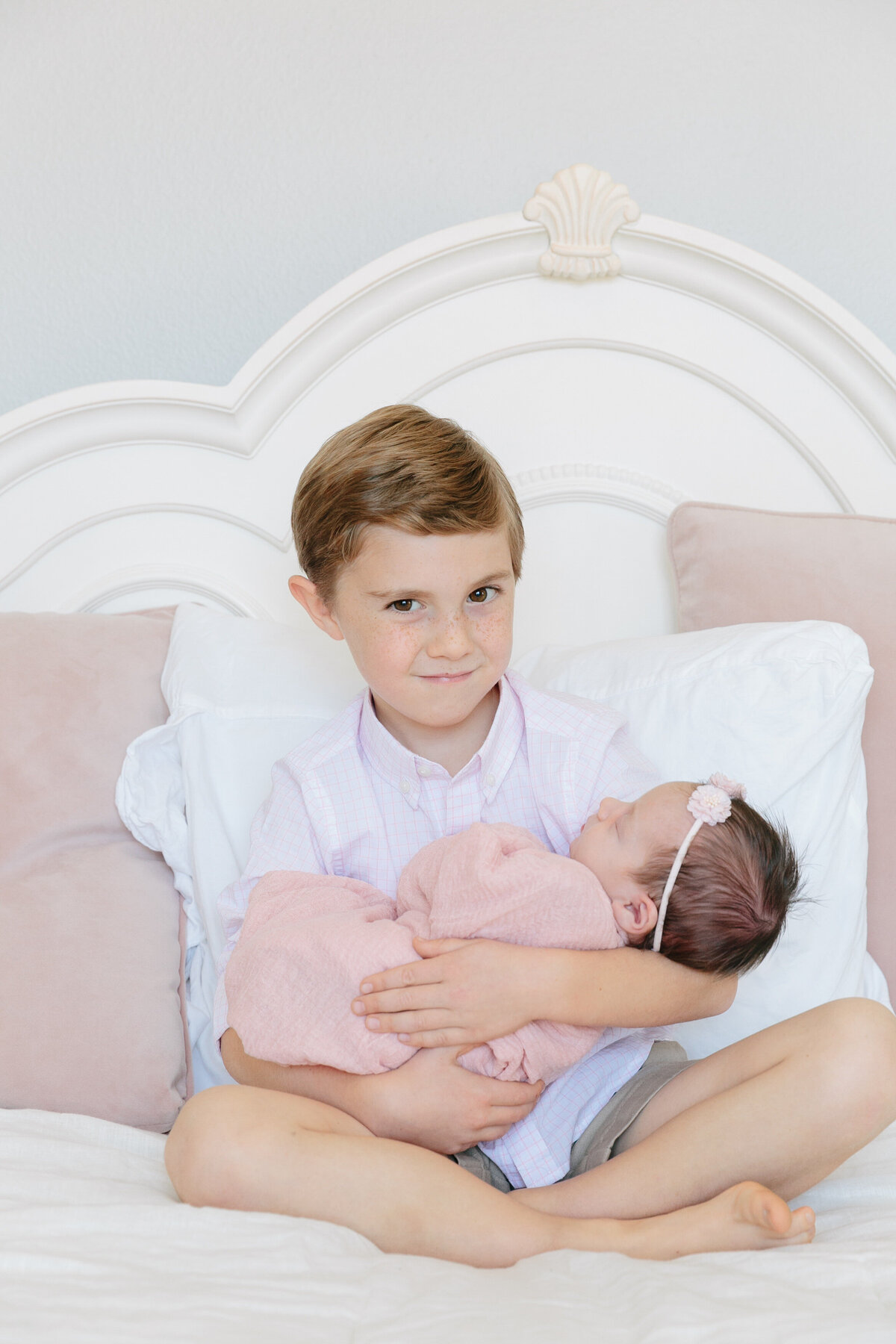 A young boy holding a newborn baby