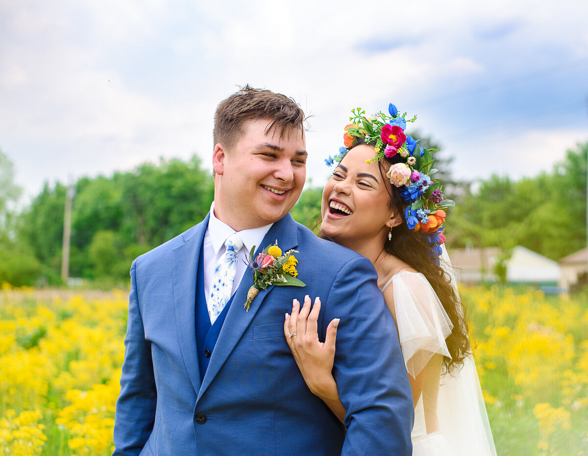 Ronicia and Jack Henderson laugh together in a field of yellow flowers in Xenia, Ohio.
