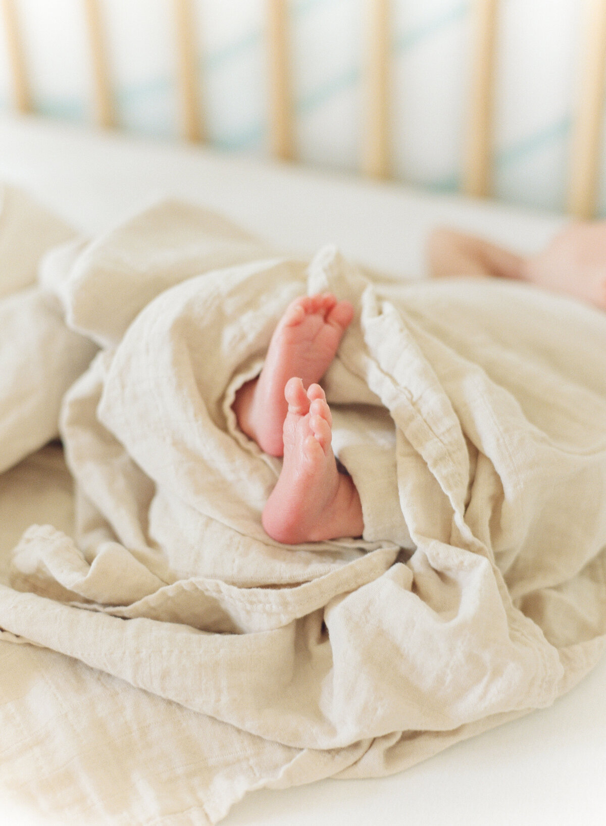 Baby toes peek out from a blanket during a Raleigh newborn session. Photographed by Raleigh Newborn Photographer A.J. Dunlap Photography.