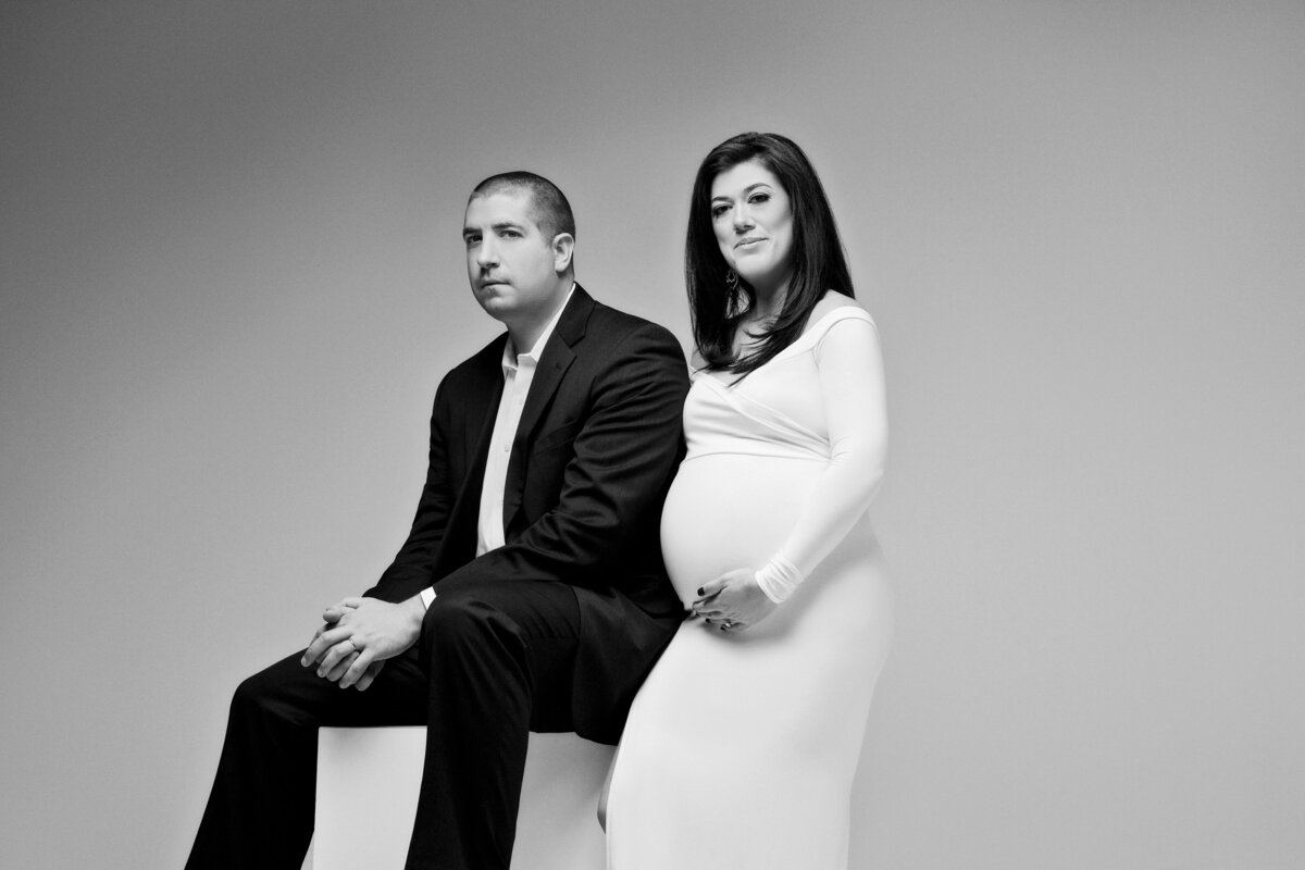 A pregnant couple sitting next to each other