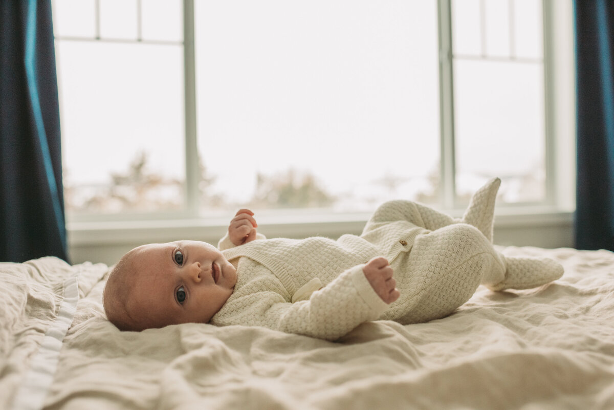 newborn baby laying on bed