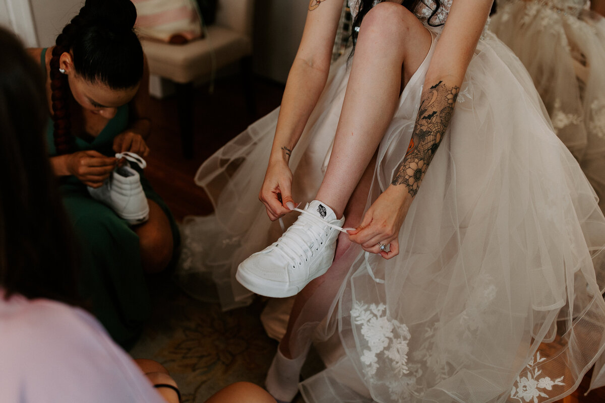bride tying vans under her dress