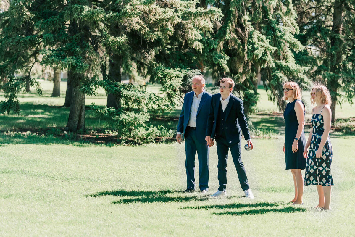 Family playing bocce bocce ball in a park. 