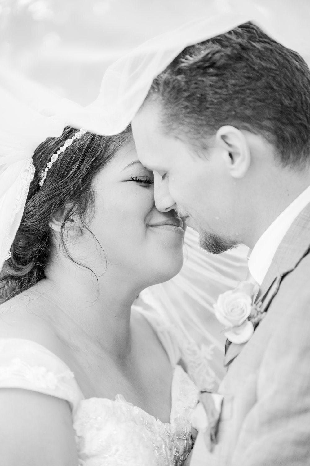 bride and groom kiss veil