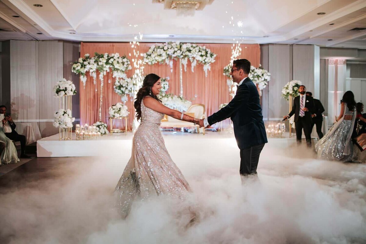 Bride and Groom share a dance while surrounded by fog​ as well as friends and family. The wedding took place in New Jersey.