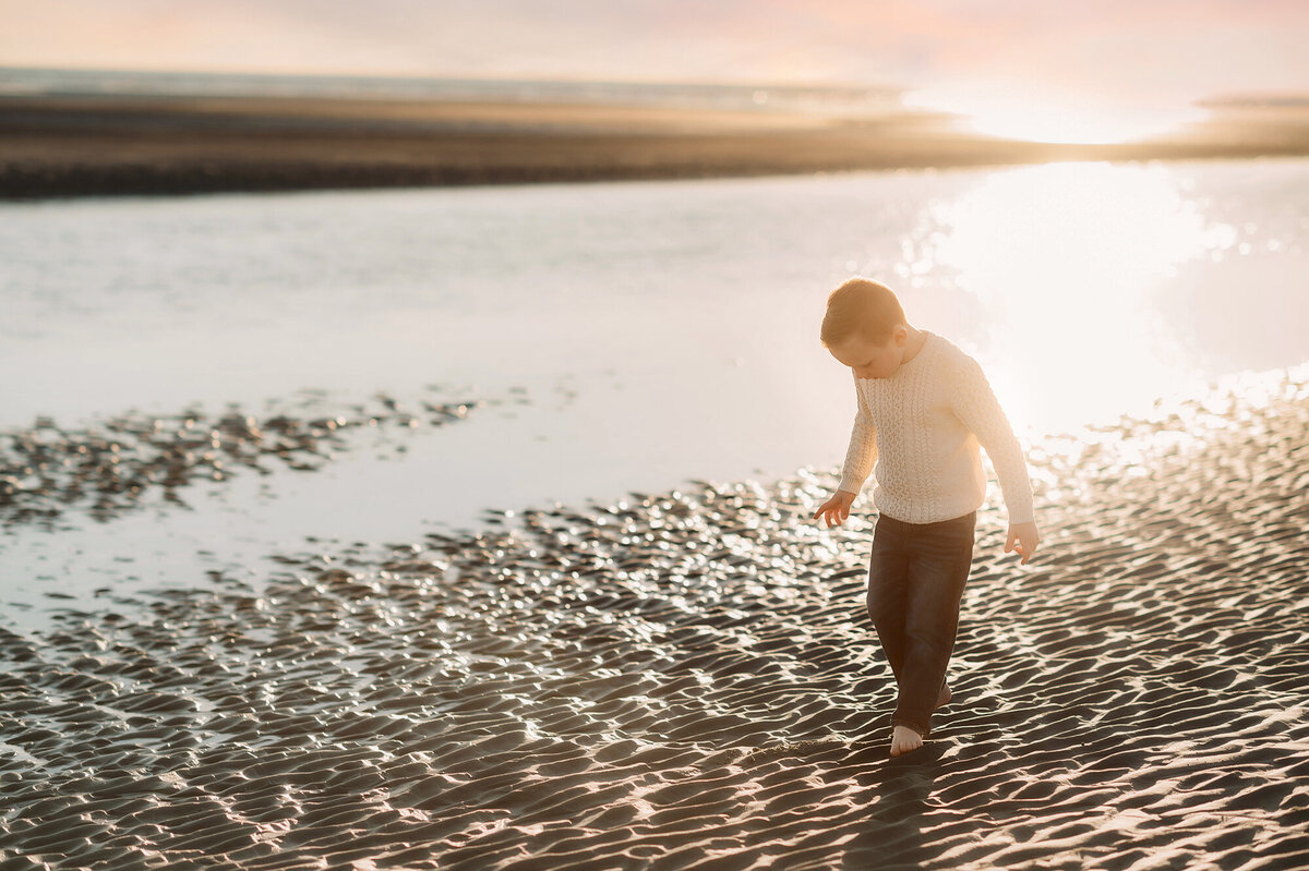 Little boy walks along the shore during Family Pictures on Kiawah Island.