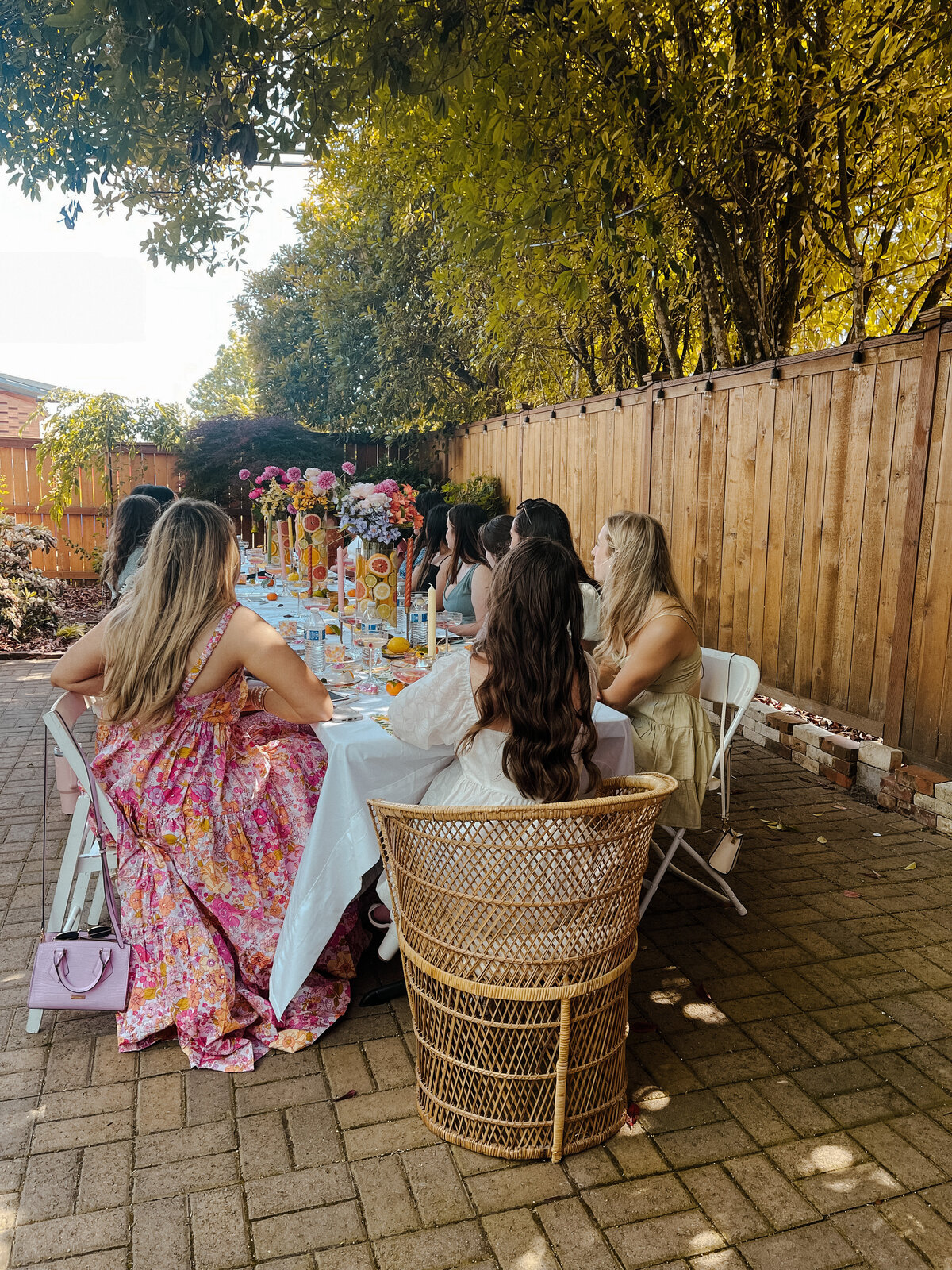 Bridal shower with the bride sitting at the head of the table and guests all around her.