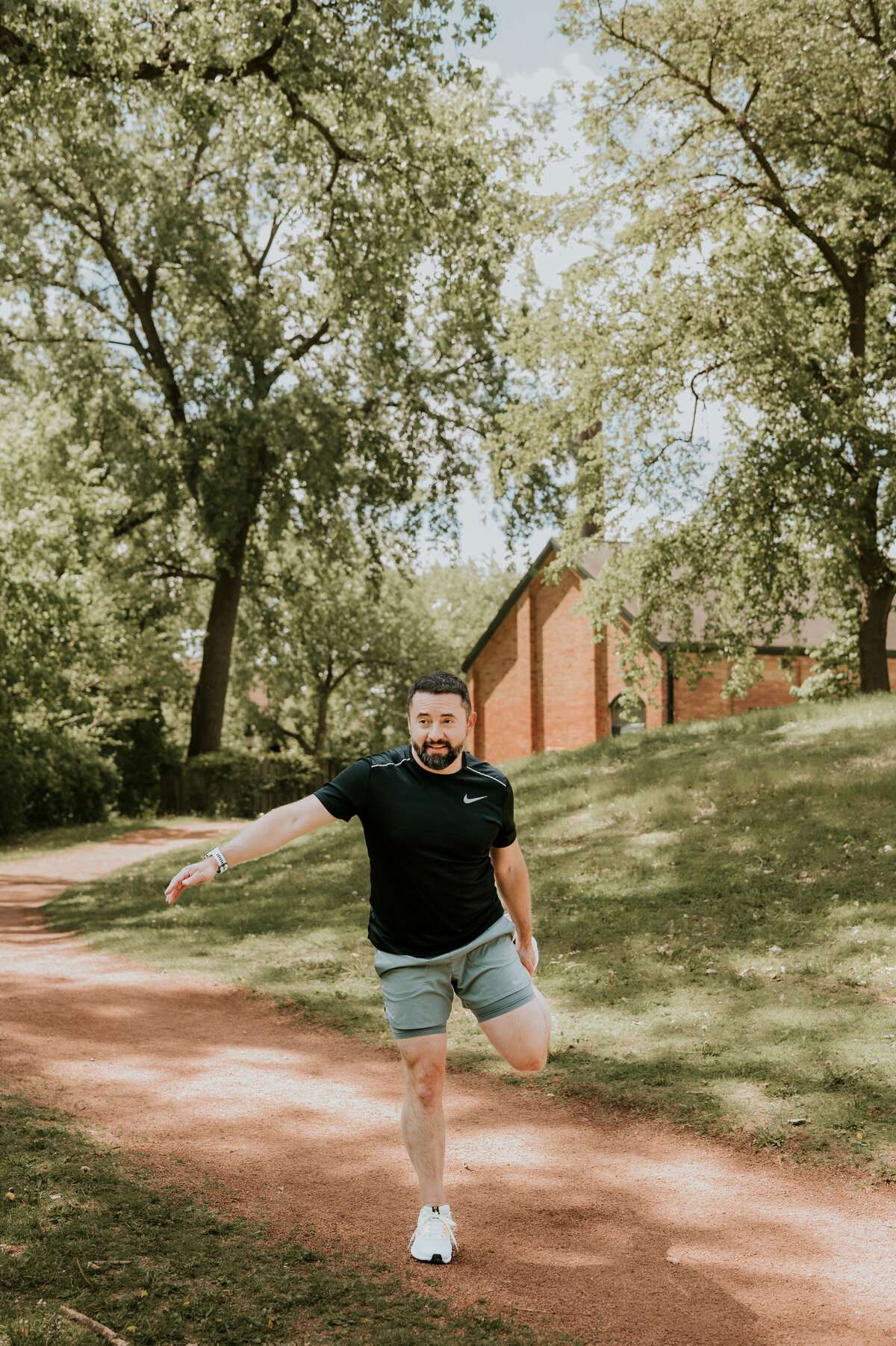 Active lifestyle dating portrait of a man stretching before a run in Minneapolis, showing personality and movement for modern dating apps.