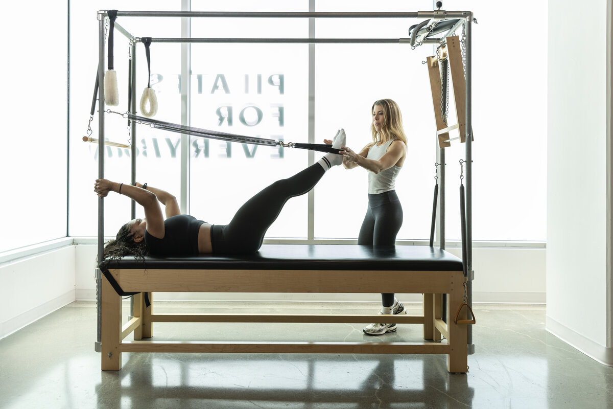Speir Instructor holding the foot of a women working on a performer