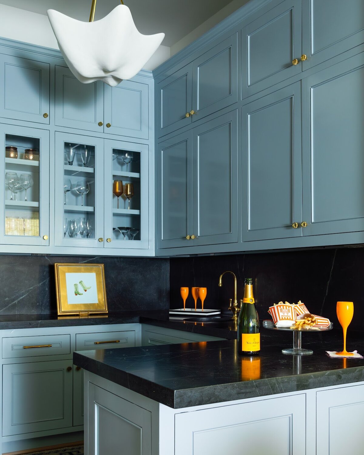 french lab designs dark counter tops with soft blue cabients