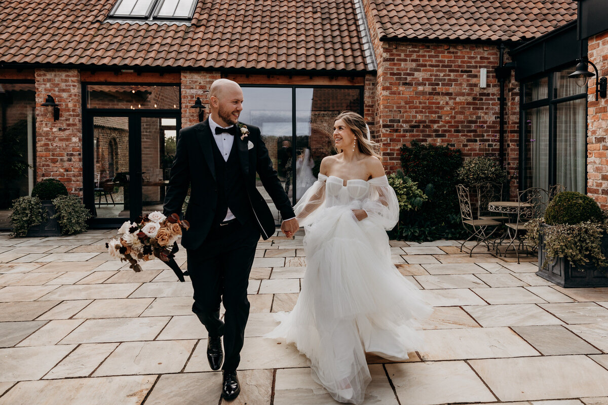 Bride and Groom running at Thirsk Lodge Barn