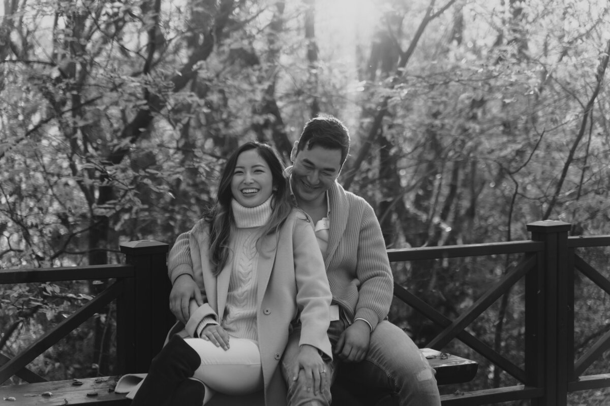 the couple smiling and sitting on the bench of damyang eco park