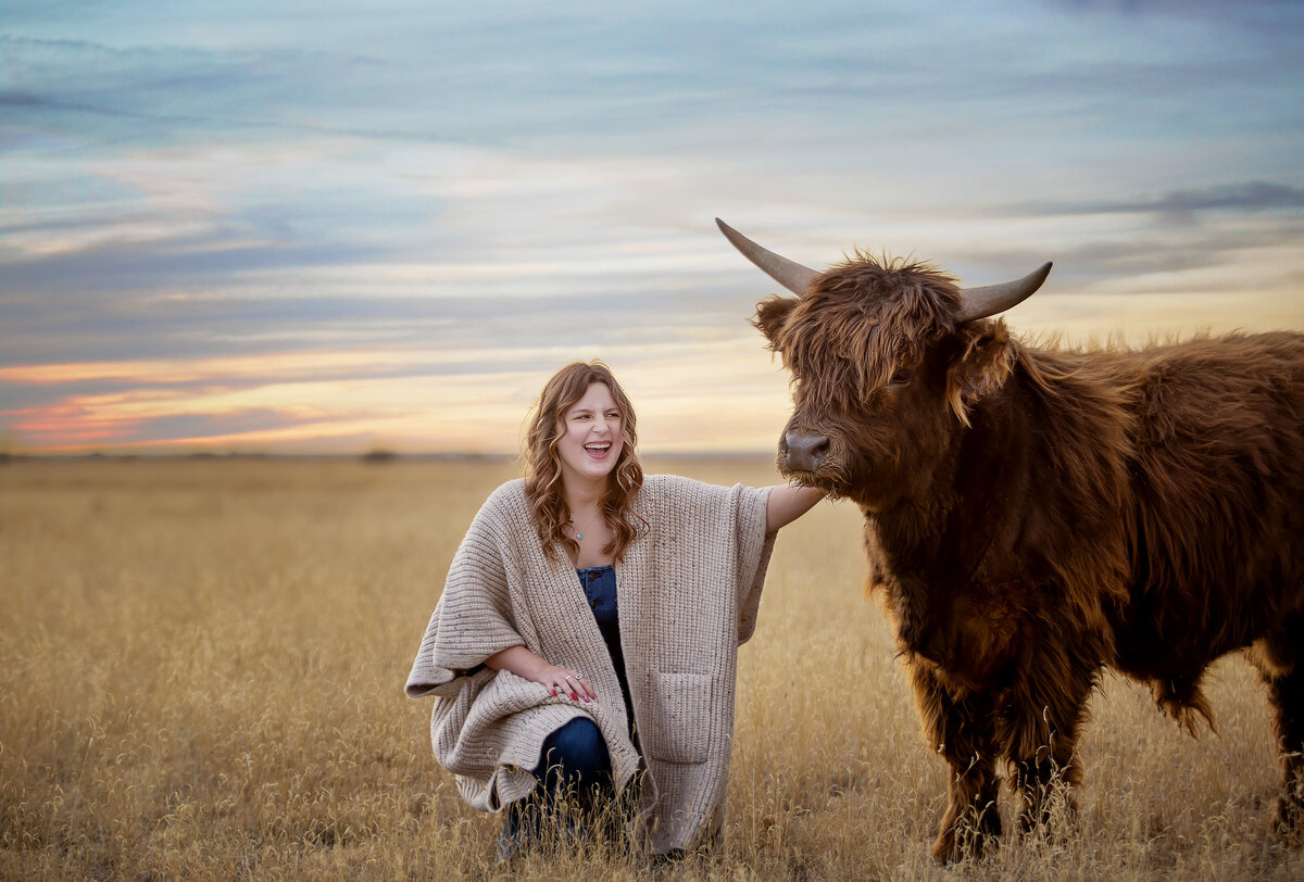 girl laughing and petting a mini highland cow in the panhandle of texas