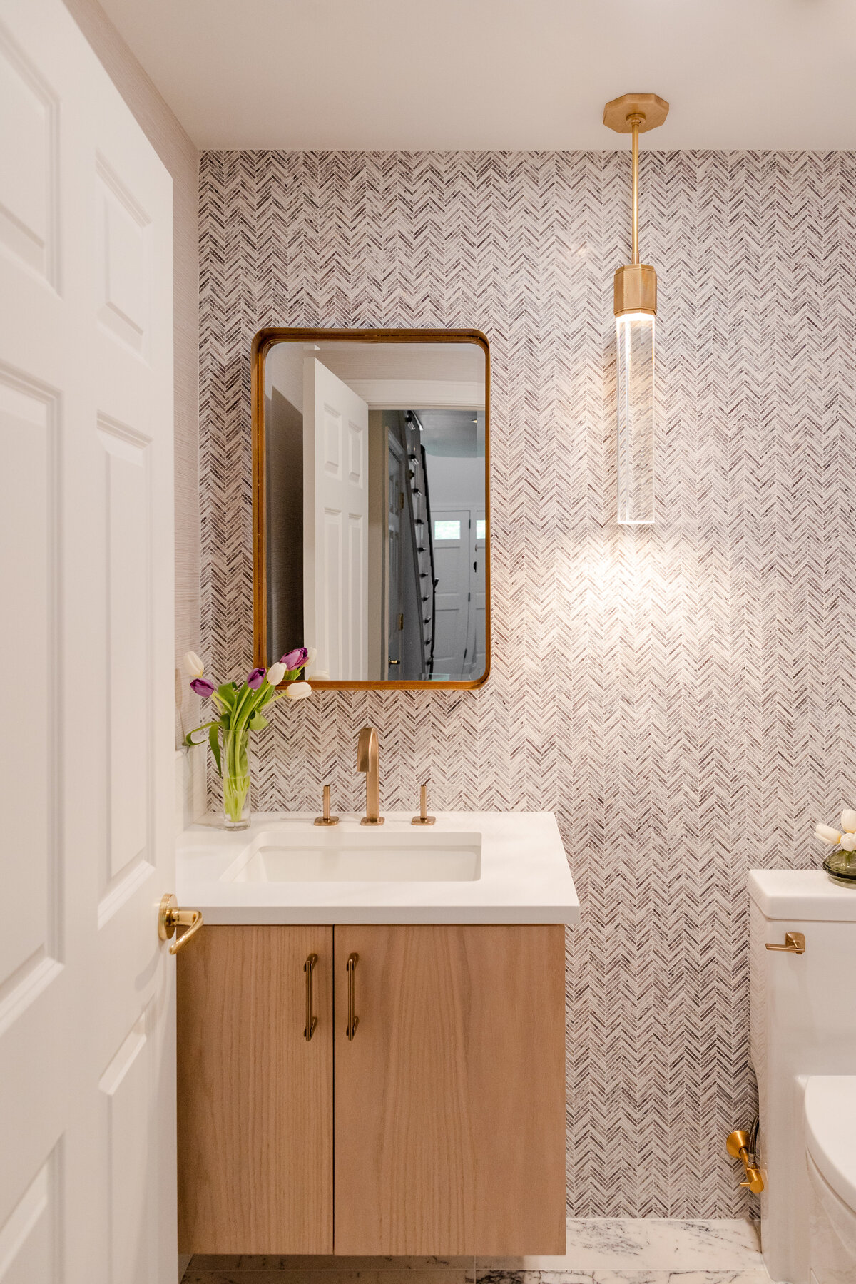 The bathroom includes a herringbone accent wall made of lilac marble, complemented by 12x24 lilac marble floor tiles.