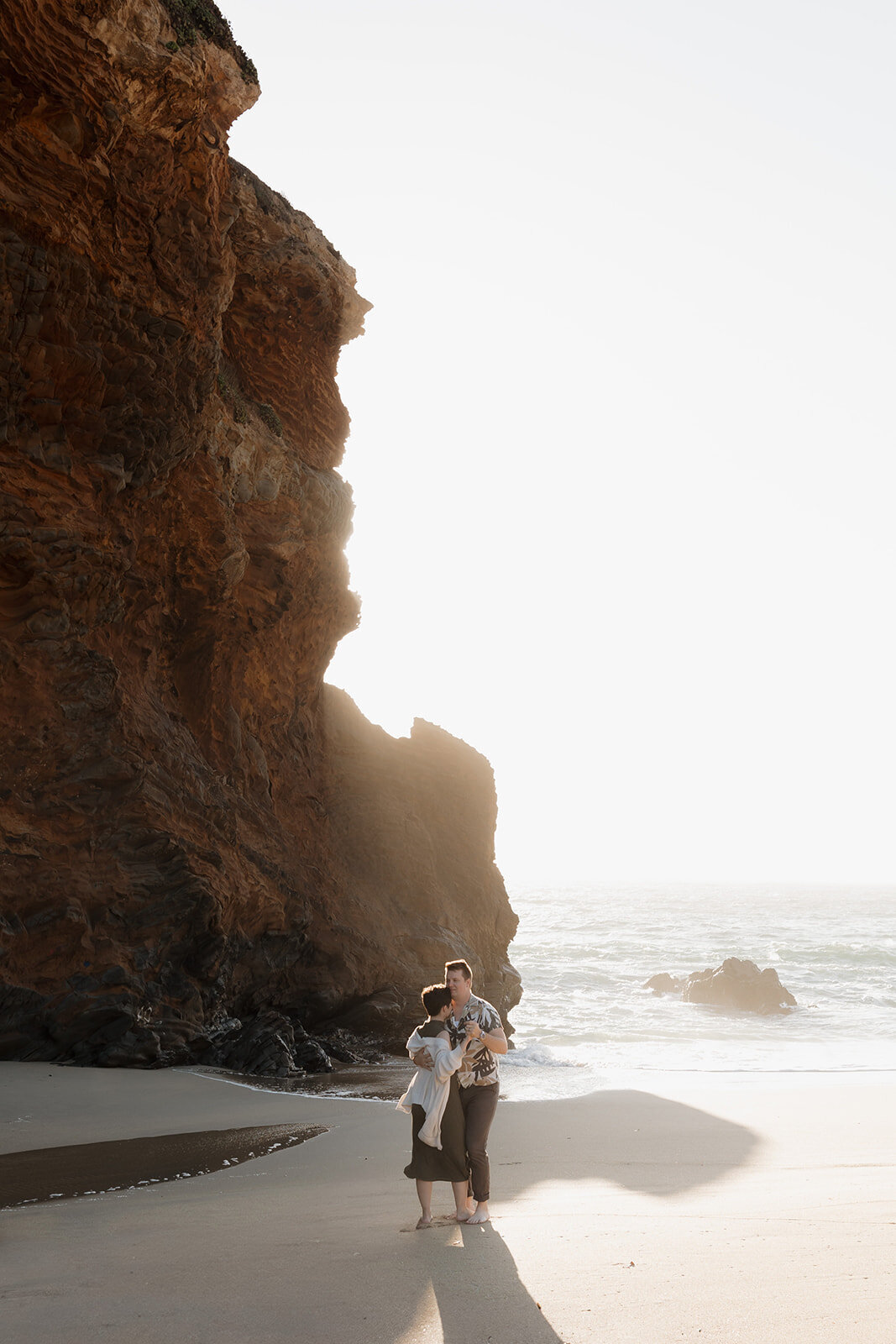 Cinematic engagement photo of a couple embracing at Panther Beach in Santa Cruz, captured by a destination wedding photographer.