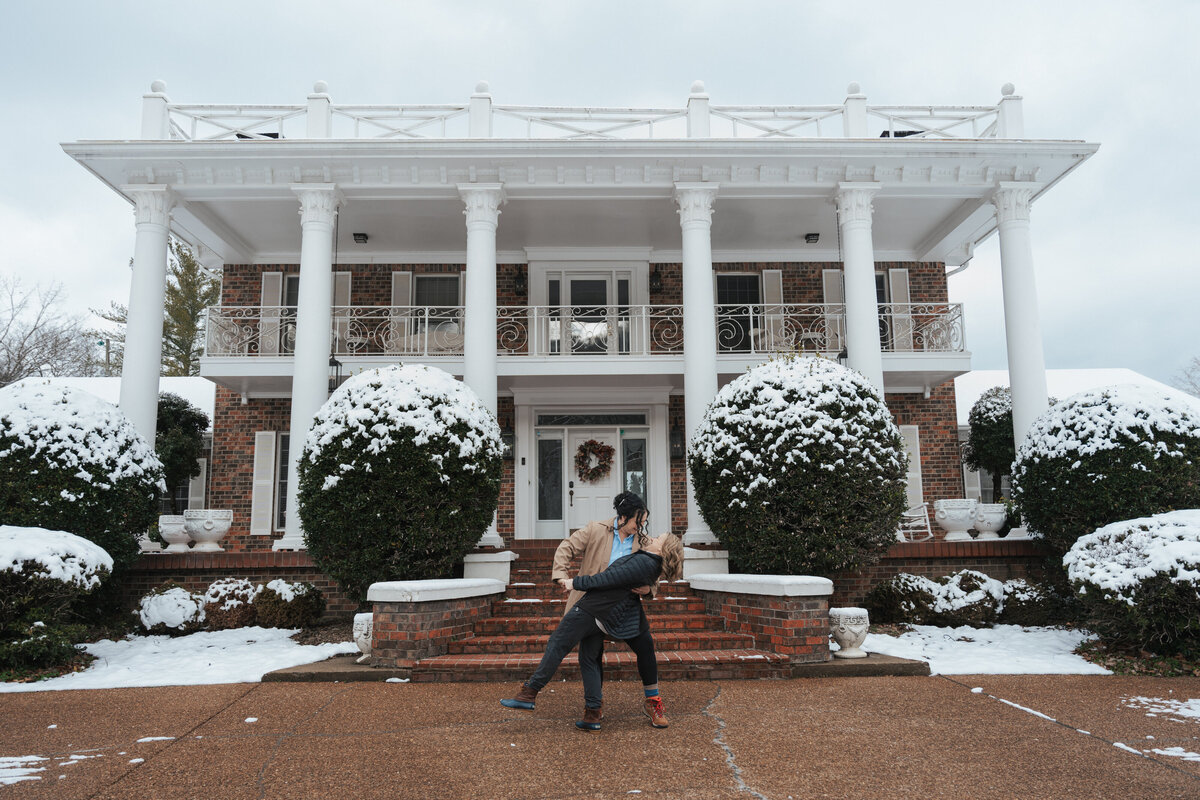 Wife dips her bride in front of a Tennessee home on their elopement day 