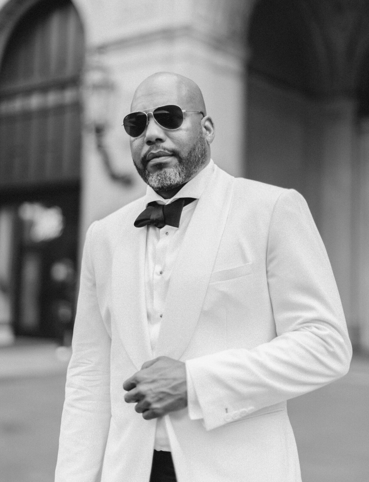Handsome black groom with sunglasses, white jacket in Detroit, Michigan