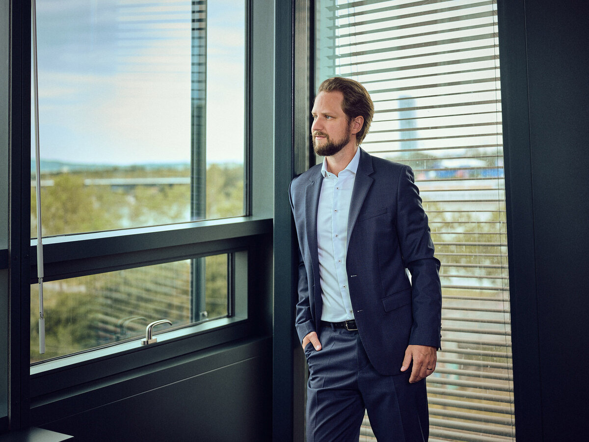 Nachdenkliches Businessportrait im modernen Büro – fotografiert von Atelier Schulte in Wien. Ideal für Geschäftsführer-Portraits mit urbanem Charakter.