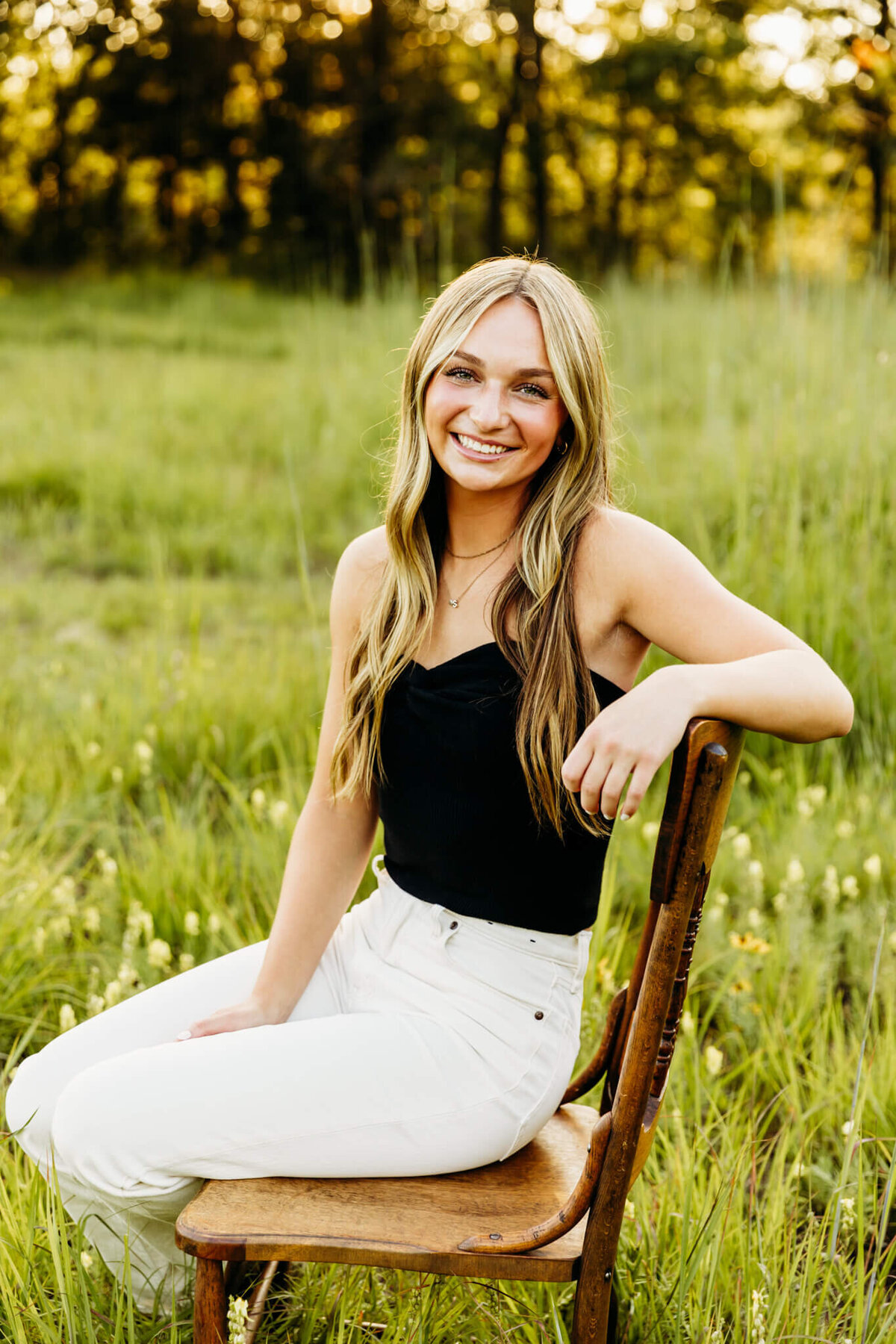 stunning young lady posing while leaning on chair in a park near Green Bay