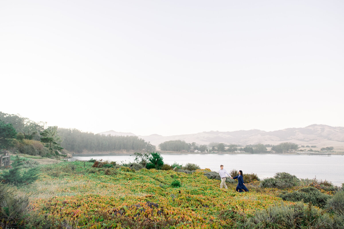 An engaged couple snuggles close for their engagement photos in Santa Cruz