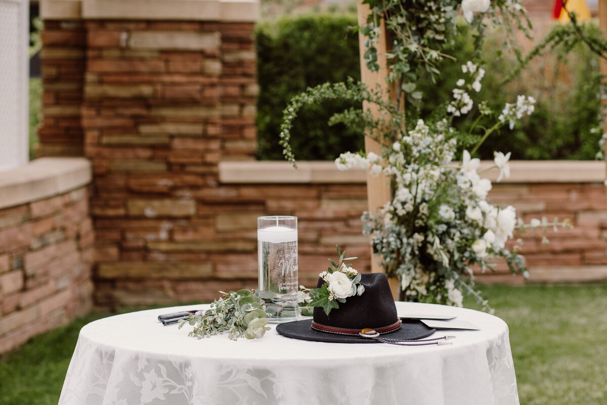 Table at the head of a wedding ceremony with white flowers and greenery in Boulder, Colorado.