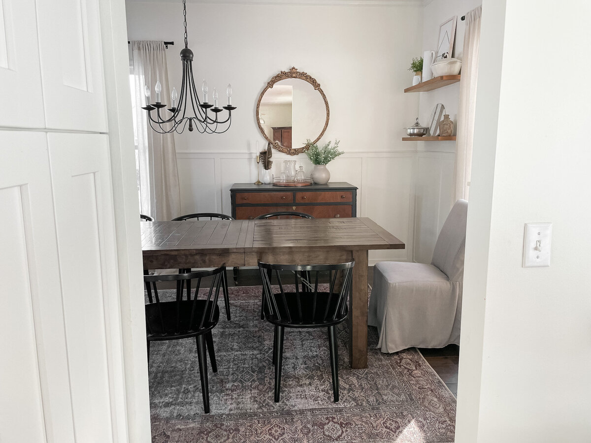 Dining room table with black chairs and Loloi area rug