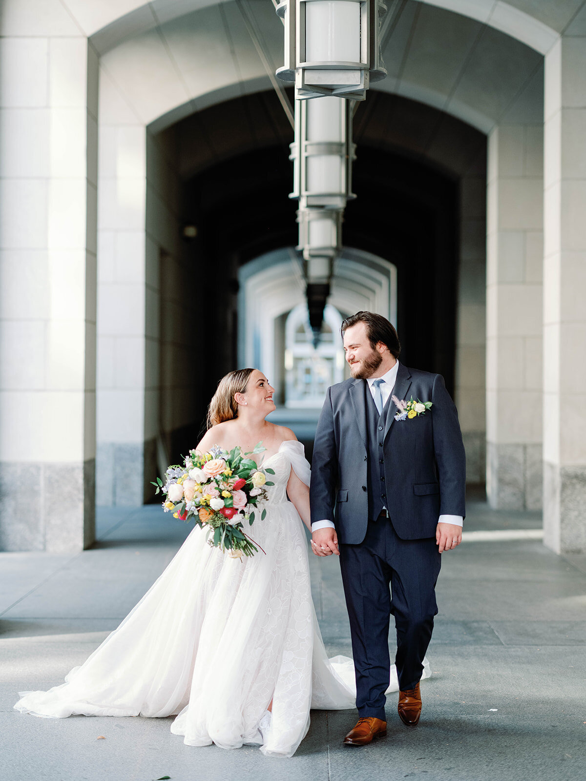 Bride and groom hold hands as they walk together