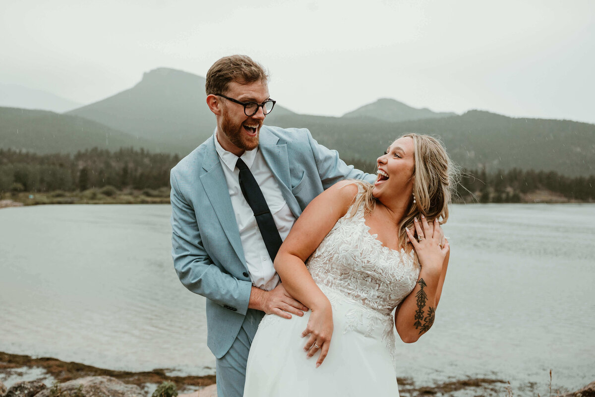 Bride and Groom Laughing by Mountain Lake