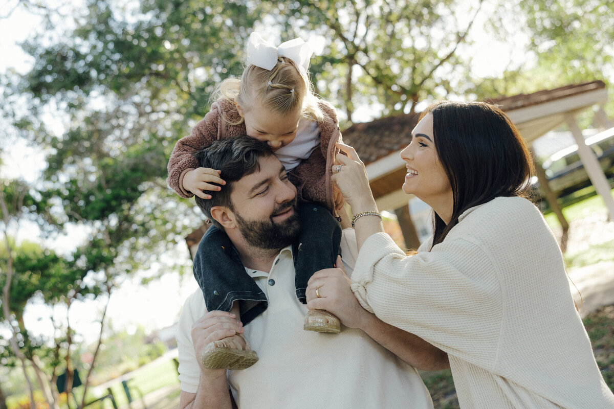 mom and dad play with daugher