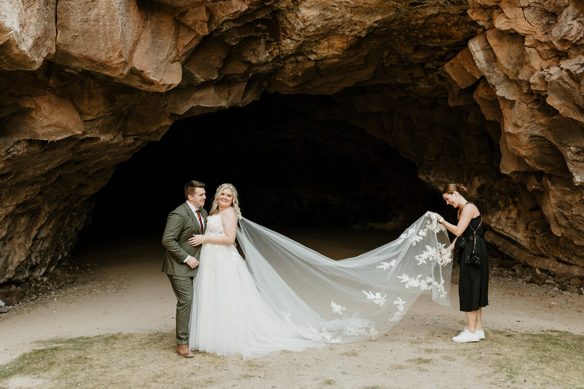 photographer fluffing bride's dress