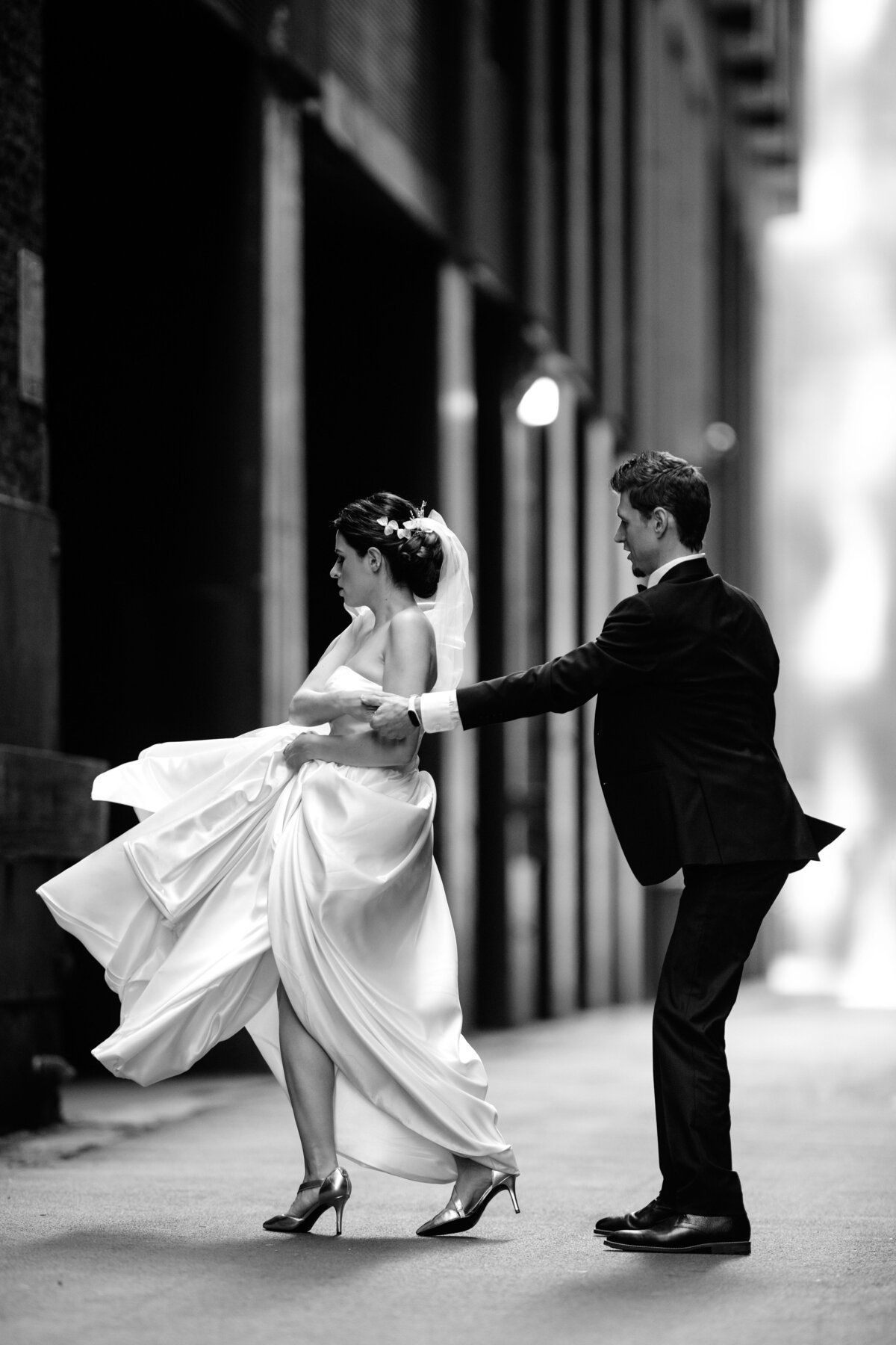 Black and white wedding  image of  groom and bride  dancing in the alley of Chicago