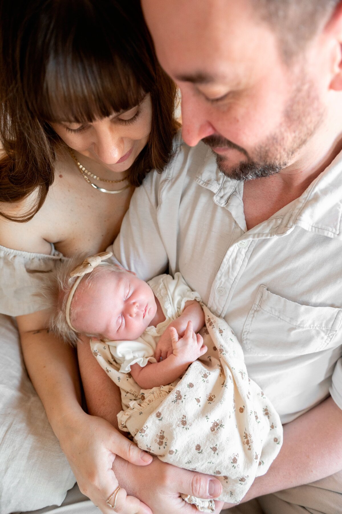 husband and wife looking down at baby