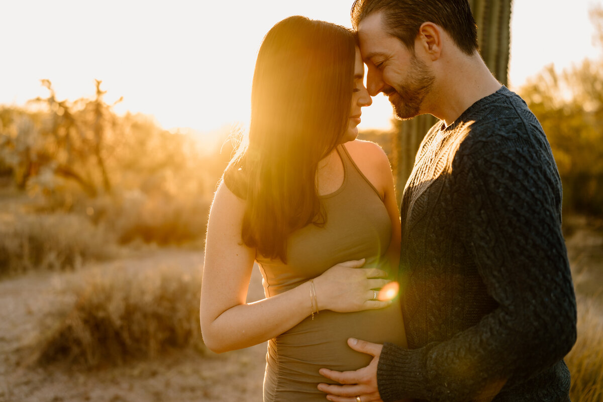 expecting couple poses at golden hour