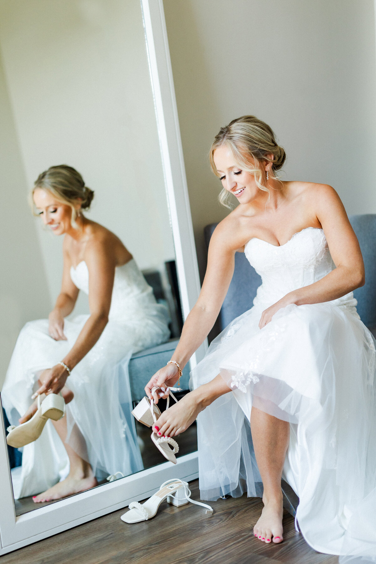 24_bride_putting_on_shoes_in_getting_ready_suite